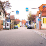 (C) DL Fotografie - Daniel Löwedey
Mit freundlicher Genehmigung der Stadtwerke Frankenthal Hauptstraße in Heßheim mit Zebrastreifen, parkenden Autos und farbenfrohen Häusern