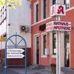 Historisches Gebäude mit Apotheke, Wegweiser zu Kindergarten und katholischer Kirche, im Zentrum von Heßheim